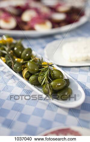A long dish of green olives on a dining table outside View Large Photo Image Stock Image - A long dish of green olives on a dining table outside . Fotosearch