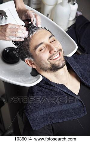 Picture - A man having his hair washed at a hair salon. Fotosearch