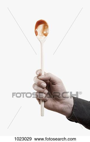 A man holding aloft a wooden spoon with red sauce on it View Large Photo Image Stock Photo - A man holding aloft a wooden spoon with red sauce on it . Fotosearch