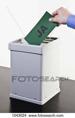 A man putting a ballot with the word JA written on it into a ballot box, close-up hands View Large Photo Image Picture - A man putting a ballot with the word JA written on it into a ballot box, close-up hands. Fotosearch