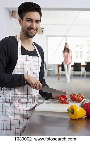 A man slicing tomatoes in a modern apartment View Large Photo Image Stock Image - A man slicing tomatoes in a modern apartment. Fotosearch