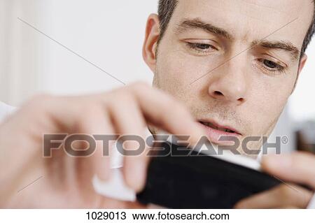 A man using a smart phone View Large Photo Image Stock Image - A man using a smart phone. Fotosearch