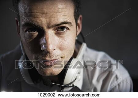 Stock Image - A man wearing a headset around his neck, close-up. Fotosearch