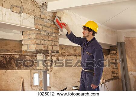 A manual worker applying plaster to a brick wall View Large Photo Image Stock Image - A manual worker applying plaster to a brick wall. Fotosearch