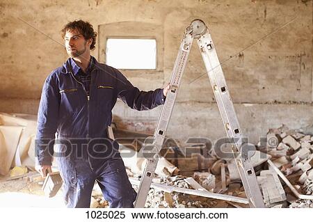 A manual worker preparing to climb a ladder View Large Photo Image Stock Photography - A manual worker preparing to climb a ladder. Fotosearch