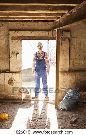 A manual worker standing in a doorway, portrait View Large Photo Image Stock Image - A manual worker standing in a doorway, portrait. Fotosearch