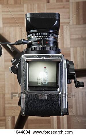 A medium format camera photographing a glass next to bottled water View Large Photo Image Picture - A medium format camera photographing a glass next to bottled water. Fotosearch