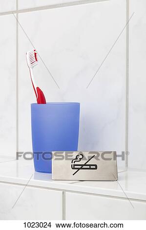 A no smoking sign next to a toothbrush in a cup View Large Photo Image Picture - A no smoking sign next to a toothbrush in a cup. Fotosearch