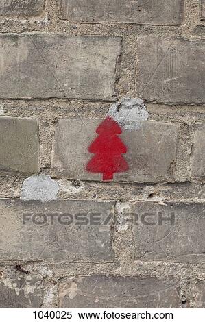 Stock Photography - A red Christmas tree stenciled on a brick wall. Fotosearch