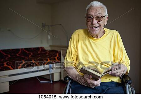 A senior man in a wheelchair flipping through a book View Large Photo Image Stock Photography - A senior man in a wheelchair flipping through a book. Fotosearch