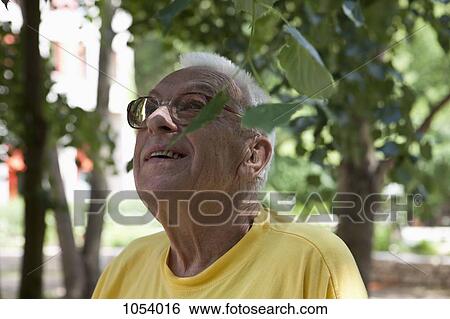 A senior man looking up, outdoors View Large Photo Image Stock Photograph - A senior man looking up, outdoors. Fotosearch
