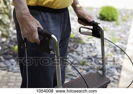 A senior man standing with a walker, midsection, outdoors View Large Photo Image Stock Photo - A senior man standing with a walker, midsection, outdoors. Fotosearch