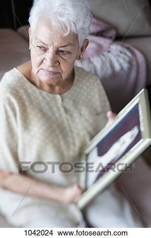 A senior woman holding a picture frame View Large Photo Image Picture - A senior woman holding a picture frame. Fotosearch
