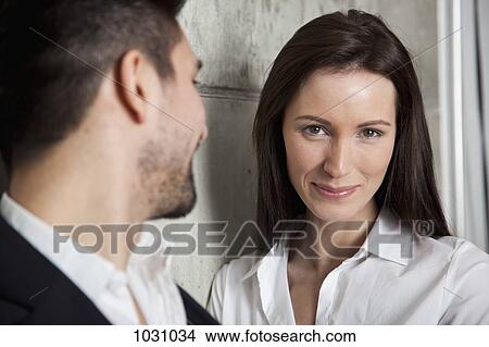 A smiling businesswoman and a businessman, focus on woman View Large Photo Image Picture - A smiling businesswoman and a businessman, focus on woman. Fotosearch