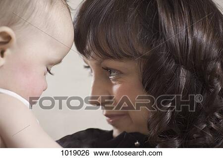 Stock Photograph - A smiling mother and her baby. Fotosearch