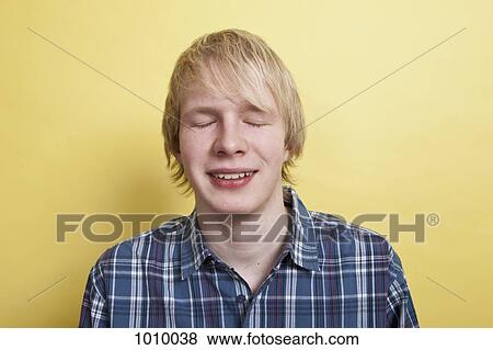 A smiling teenage boy with eyes closed, portrait, studio shot View Large Photo Image Stock Photo - A smiling teenage boy with eyes closed, portrait, studio shot. Fotosearch