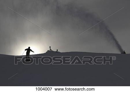 A snow machine spraying snow by a skier on a ski slope View Large Photo Image Stock Photo - A snow machine spraying snow by a skier on a ski slope. Fotosearch