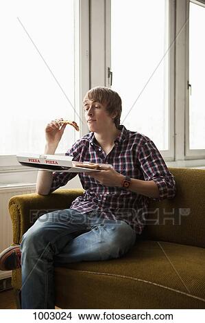 A teenage boy eating delivery pizza View Large Photo Image Picture - A teenage boy eating delivery pizza. Fotosearch