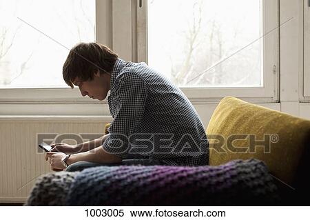 A teenage boy text messaging View Large Photo Image Stock Photography - A teenage boy text messaging. Fotosearch