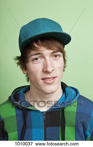 A teenage boy wearing a hoodie and baseball cap, portrait, studio shot View Large Photo Image Stock Photo - A teenage boy wearing a hoodie and baseball cap, portrait, studio shot. Fotosearch