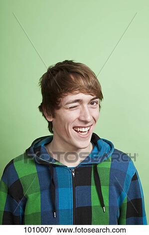 A teenage boy winking playfully, portrait, studio shot View Large Photo Image Stock Photo - A teenage boy winking playfully, portrait, studio shot. Fotosearch
