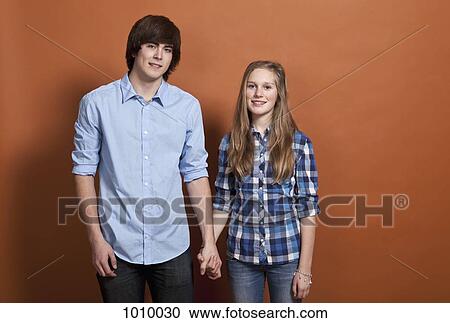 Stock Image - A teenage, heterosexual couple, portrait, studio shot. Fotosearch