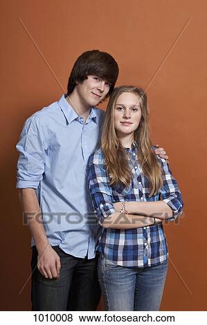 Stock Photo - A teenage, heterosexual couple, portrait, studio shot. Fotosearch