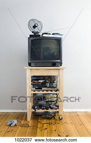 A television set on a cabinet with lots of DVDs and video games View Large Photo Image Stock Photo - A television set on a cabinet with lots of DVDs and video games. Fotosearch