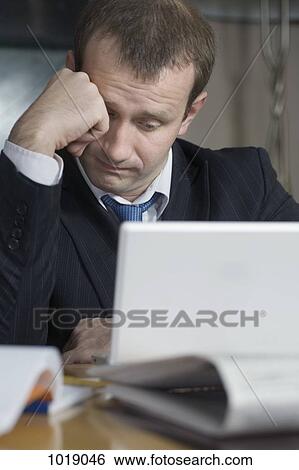 A tired businessman working late View Large Photo Image Stock Photograph - A tired businessman working late. Fotosearch