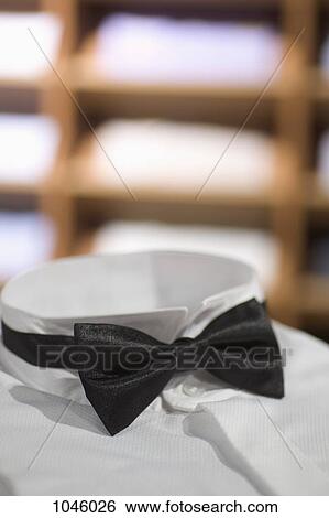 A tuxedo shirt and bow tie, close-up of bow tie, in a menswear store View Large Photo Image Stock Photograph - A tuxedo shirt and bow tie, close-up of bow tie, in a menswear store. Fotosearch