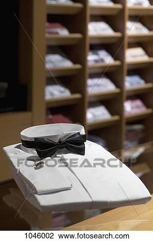 A tuxedo shirt and bow tie in a menswear store View Large Photo Image Stock Image - A tuxedo shirt and bow tie in a menswear store. Fotosearch