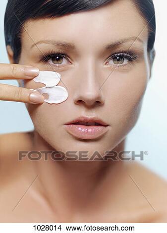 A woman applying cold cream on her cheek View Large Photo Image Picture - A woman applying cold cream on her cheek. Fotosearch