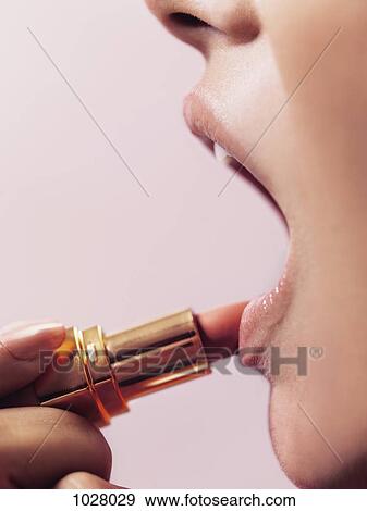 A woman applying lipstick, close-up of lips View Large Photo Image Stock Photo - A woman applying lipstick, close-up of lips. Fotosearch