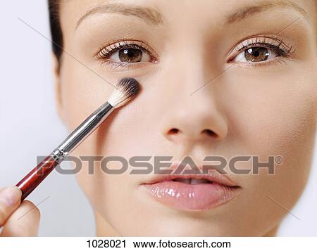 A woman applying make-up using a make-up brush View Large Photo Image Stock Image - A woman applying make-up using a make-up brush. Fotosearch