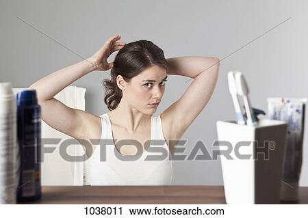 A woman considering her hairstyle View Large Photo Image Stock Image - A woman considering her hairstyle. Fotosearch