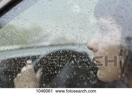 A woman driver sitting in car looking out window, raindrops on window View Large Photo Image Stock Image - A woman driver sitting in car looking out window, raindrops on window. Fotosearch