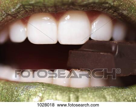 A woman eating a piece of chocolate, extreme close up of mouth View Large Photo Image Stock Photo - A woman eating a piece of chocolate, extreme close up of mouth. Fotosearch
