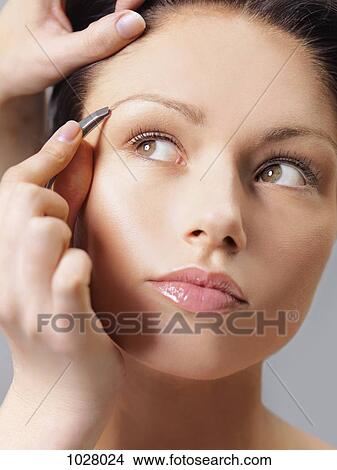 A woman having her eyebrows tweezed, close-up View Large Photo Image Picture - A woman having her eyebrows tweezed, close-up. Fotosearch