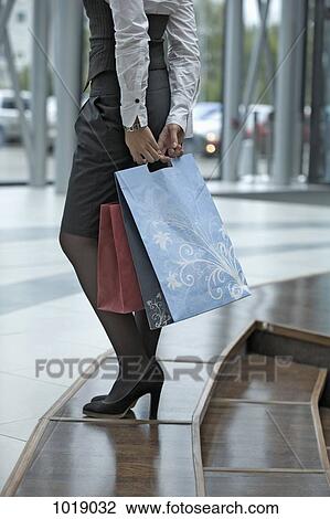Stock Image - A woman holding shopping bags. Fotosearch