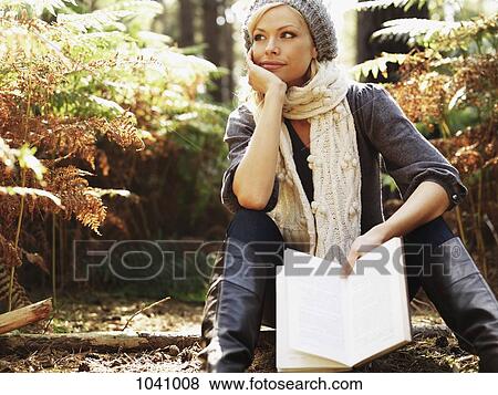 A woman in contemplation holding a book, outdoors View Large Photo Image Stock Photo - A woman in contemplation holding a book, outdoors. Fotosearch