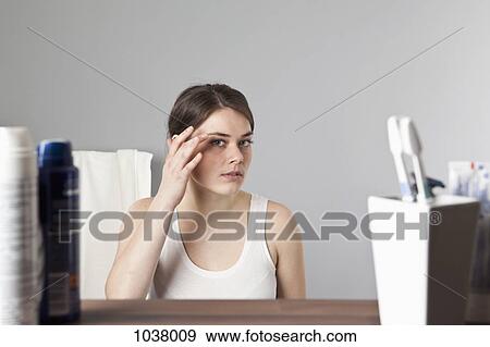 A woman inspecting her face View Large Photo Image Stock Photo - A woman inspecting her face . Fotosearch