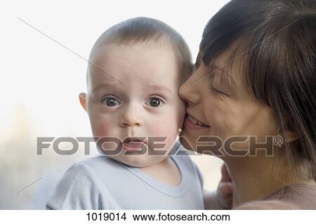 A woman kissing her surprised baby boy View Large Photo Image Picture - A woman kissing her surprised baby boy. Fotosearch