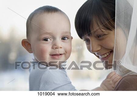 A woman laughing with her baby boy View Large Photo Image Picture - A woman laughing with her baby boy. Fotosearch