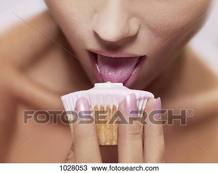 A woman licking frosting on a cupcake, focus on mouth View Large Photo Image Stock Image - A woman licking frosting on a cupcake, focus on mouth. Fotosearch