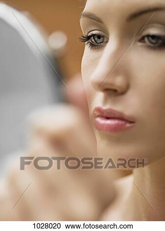 A woman looking in a mirror, close-up of face View Large Photo Image Stock Image - A woman looking in a mirror, close-up of face. Fotosearch