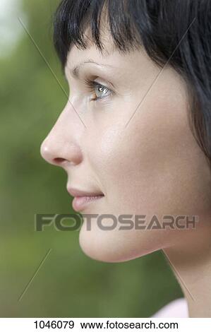 Stock Photo - A woman looking off camera, close-up. Fotosearch