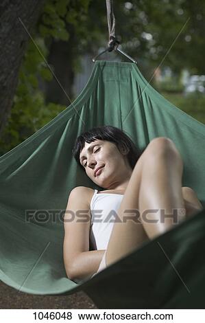 A woman lying in a hammock, eyes closed View Large Photo Image Stock Photo - A woman lying in a hammock, eyes closed. Fotosearch