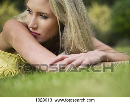 A woman lying in the summer grass, close-up, surface level View Large Photo Image Stock Image - A woman lying in the summer grass, close-up, surface level. Fotosearch