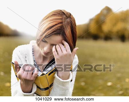 A woman reading a book, outdoors View Large Photo Image Stock Photo - A woman reading a book, outdoors. Fotosearch