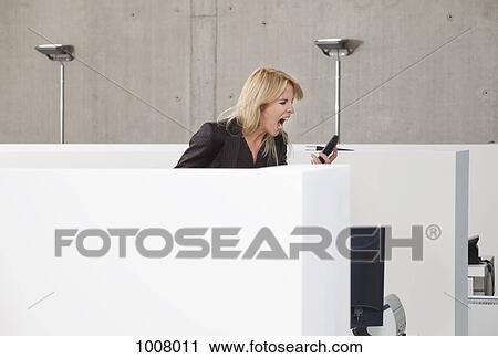 A woman screaming into a mobile phone in an office cubicle View Large Photo Image Stock Image - A woman screaming into a mobile phone in an office cubicle. Fotosearch